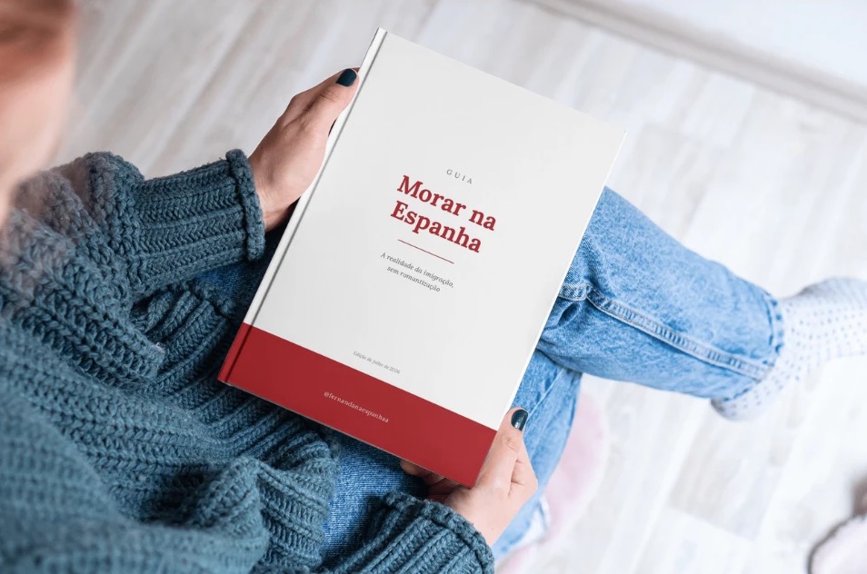 Pessoa sentada lendo o Guia Morar na Espanha, com a capa à mostra